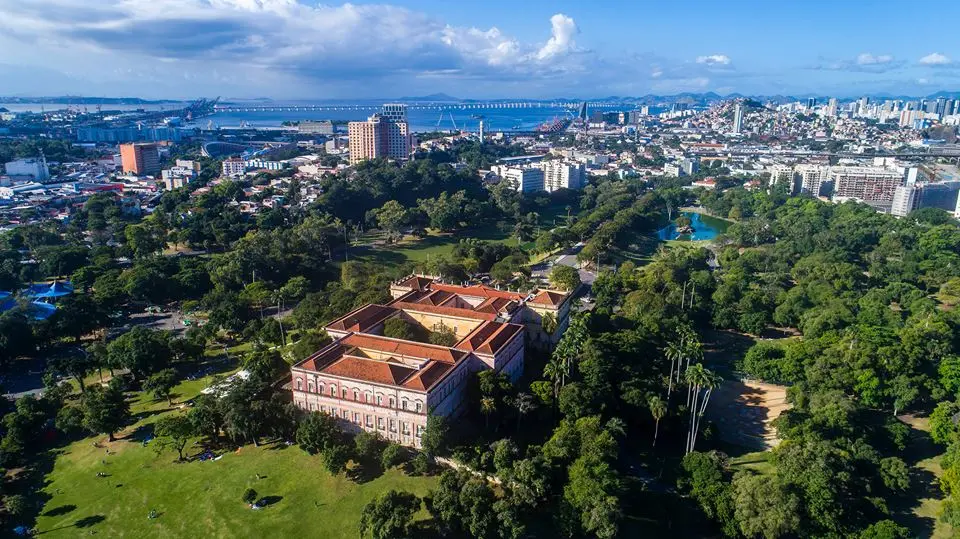 Parque com palácio histórico e áreas verdes.