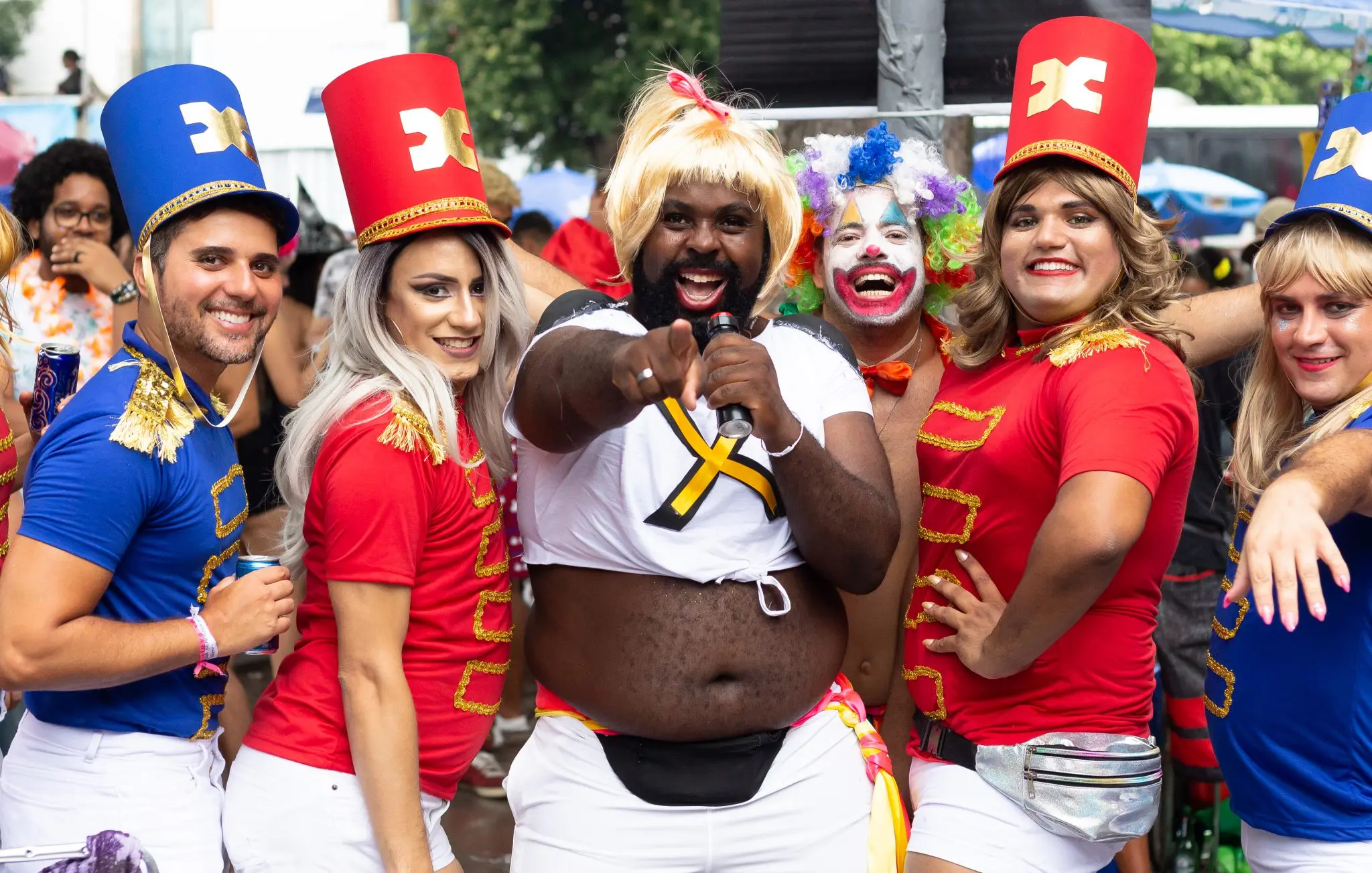 Um grupo festivo em carnaval com uniformes coloridos e detalhes dourados.