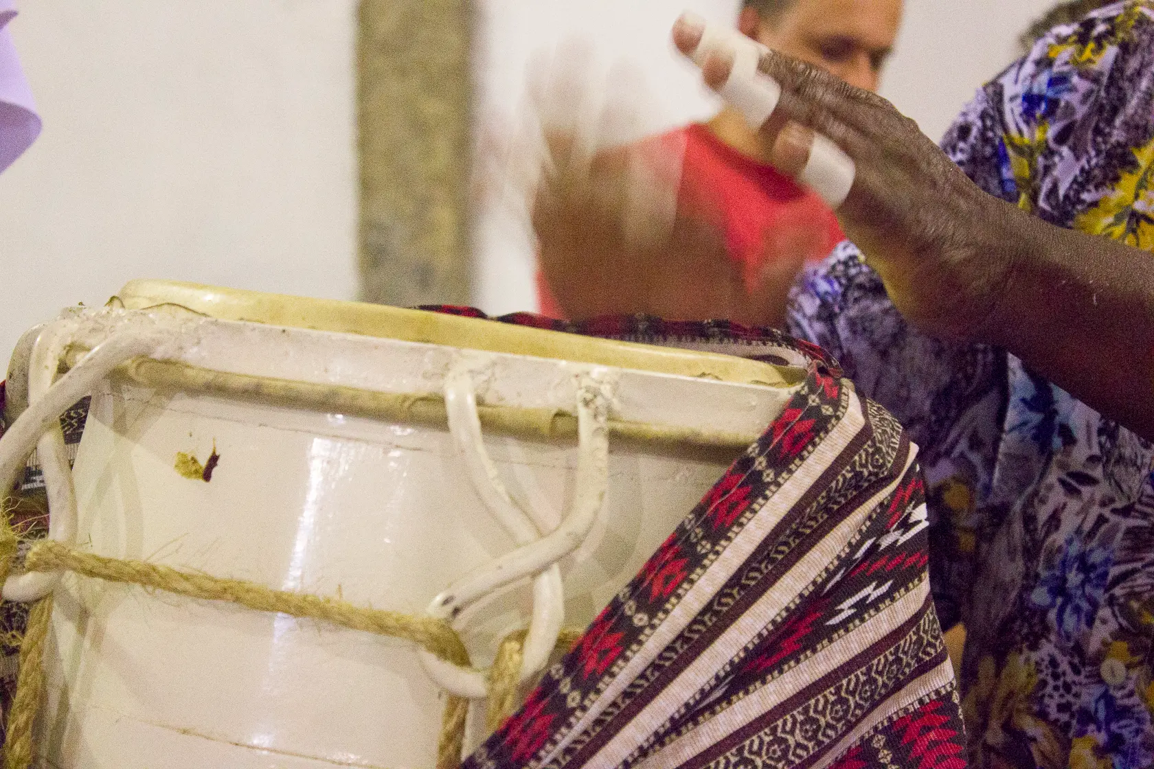 Pessoa tocando instrumento musical tradicional com fita adesiva.