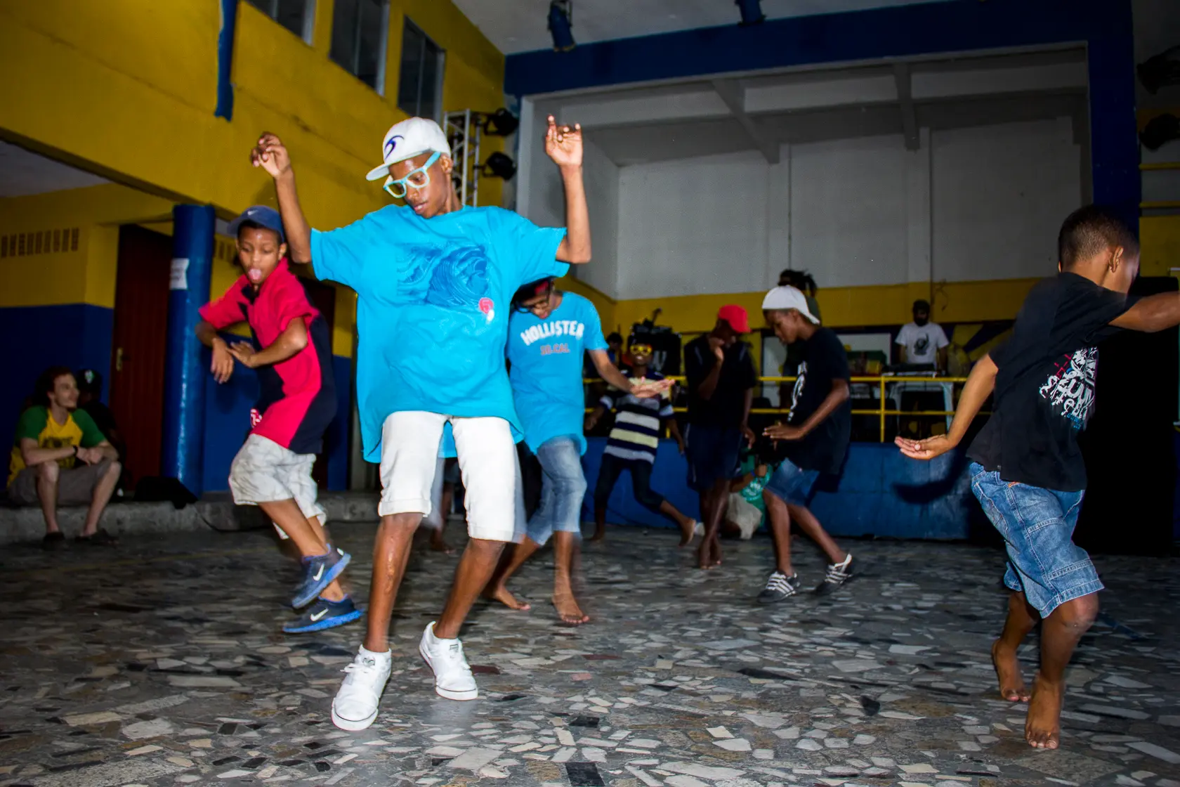 Grupo dançando em ambiente interno com crianças e adultos.