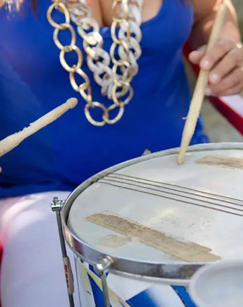 Mulher tocando instrumento musical ao ar livre.