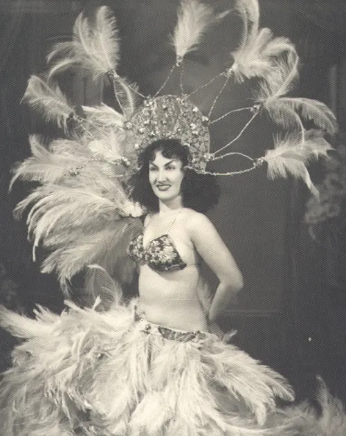Mulher dançarina em traje de revista, sorrindo para a câmera.