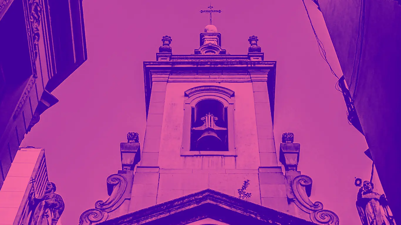 Edifício religioso com torre e estátuas humanas.