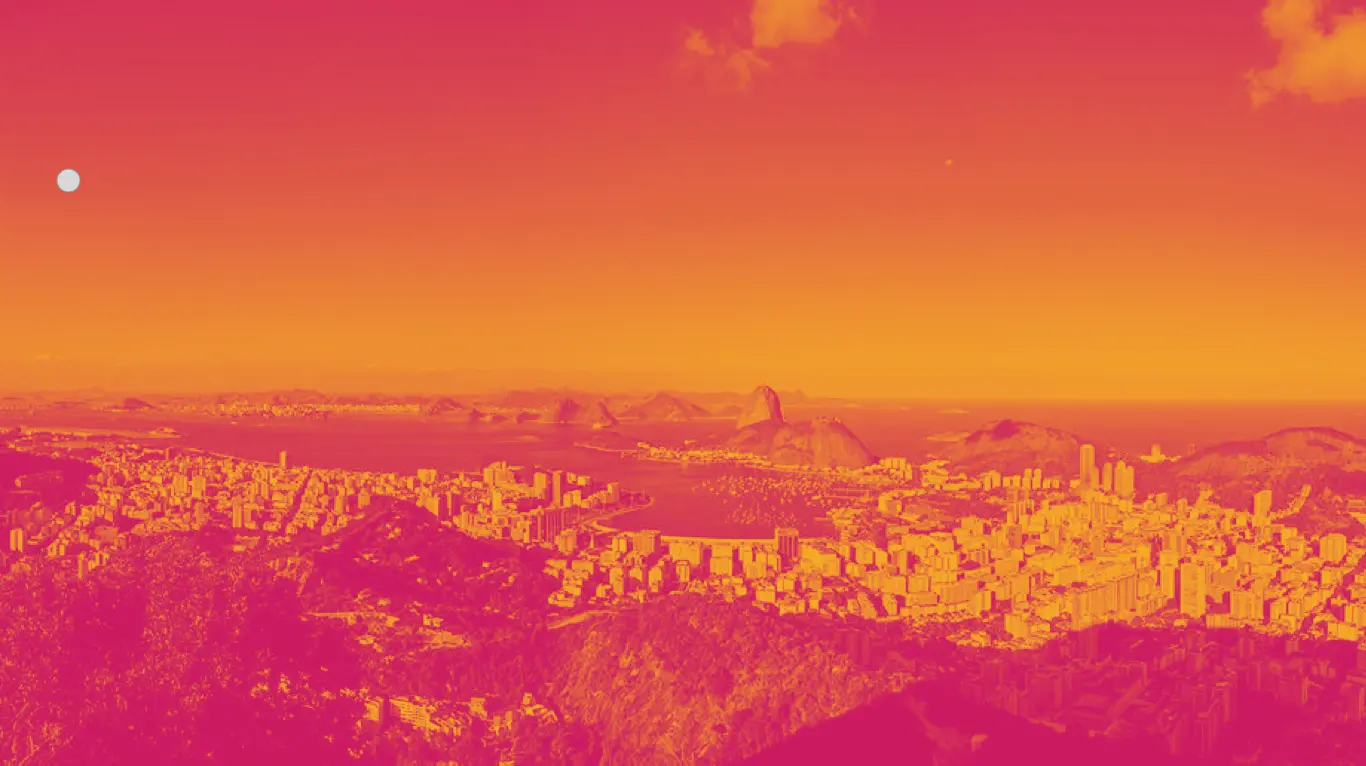 Cidade com edifícios, parque e montanhas ao fundo.