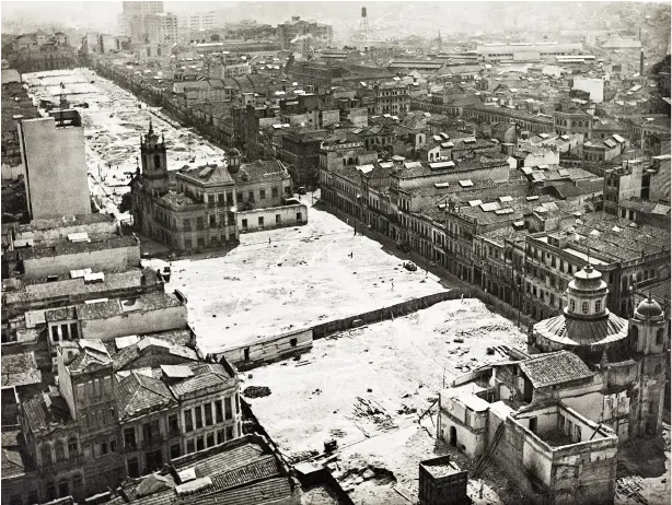 Edifícios históricos cobertos de neve em praça urbana.
