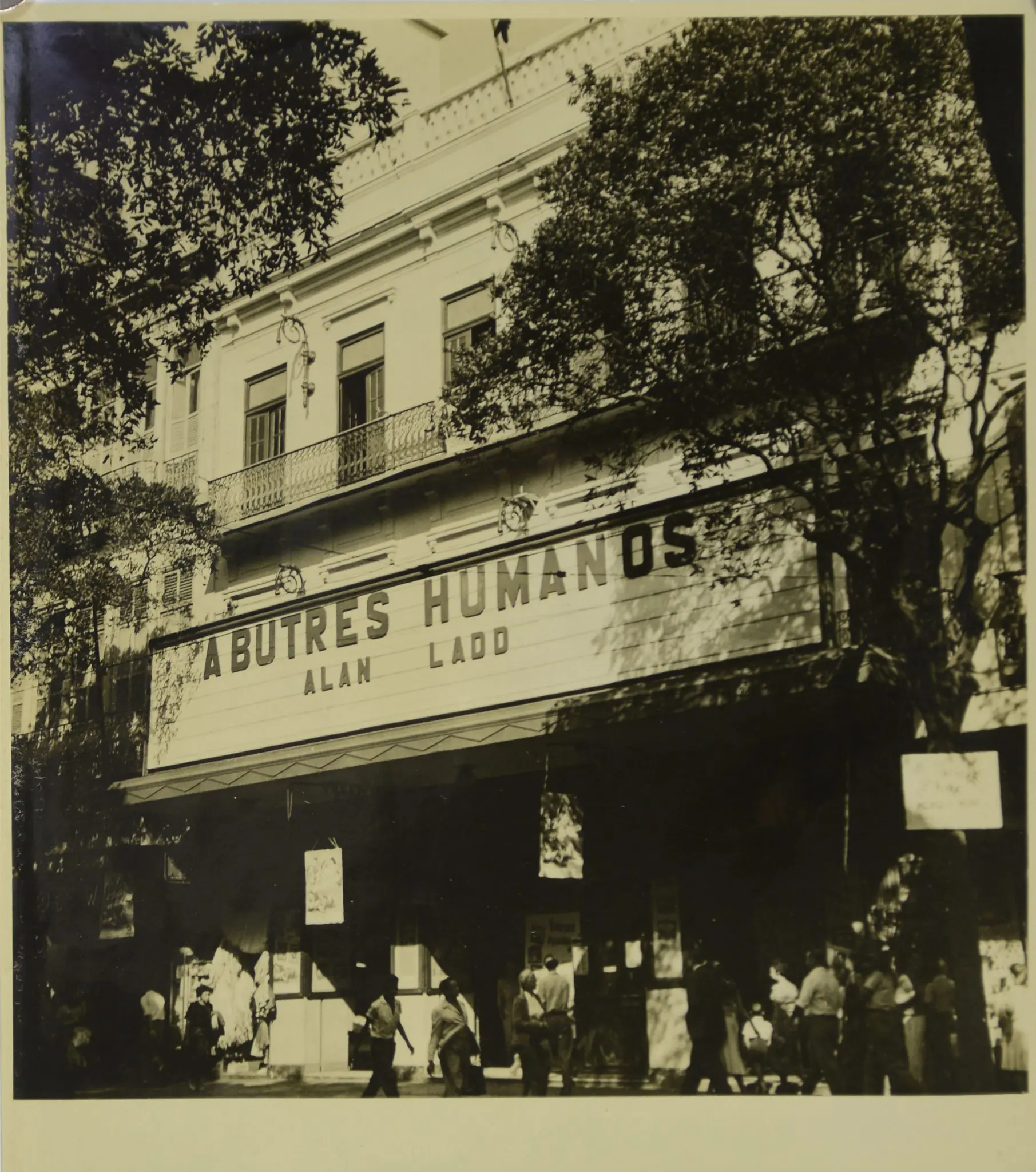 Teatro preto e branco com entrada lotada.