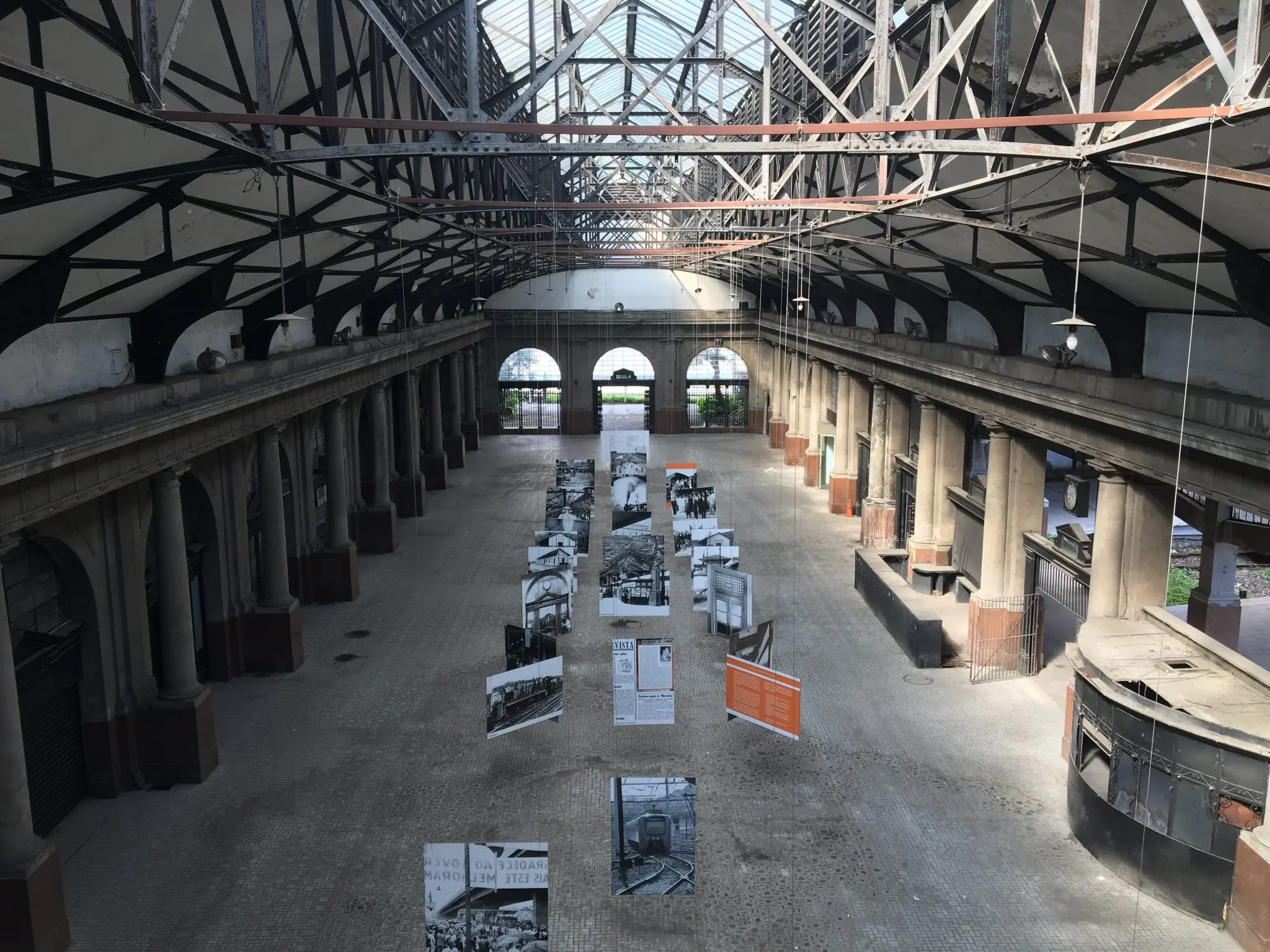 Interior de estação ferroviária com exposição temporária de fotos.