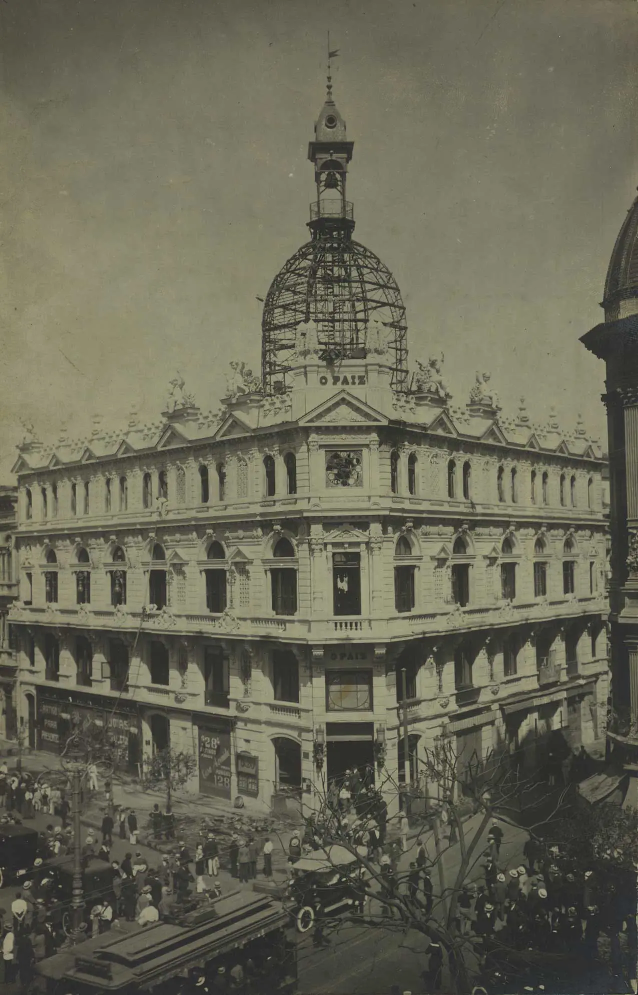 Edifício neoclássico em esquina com árvore sem folhas.