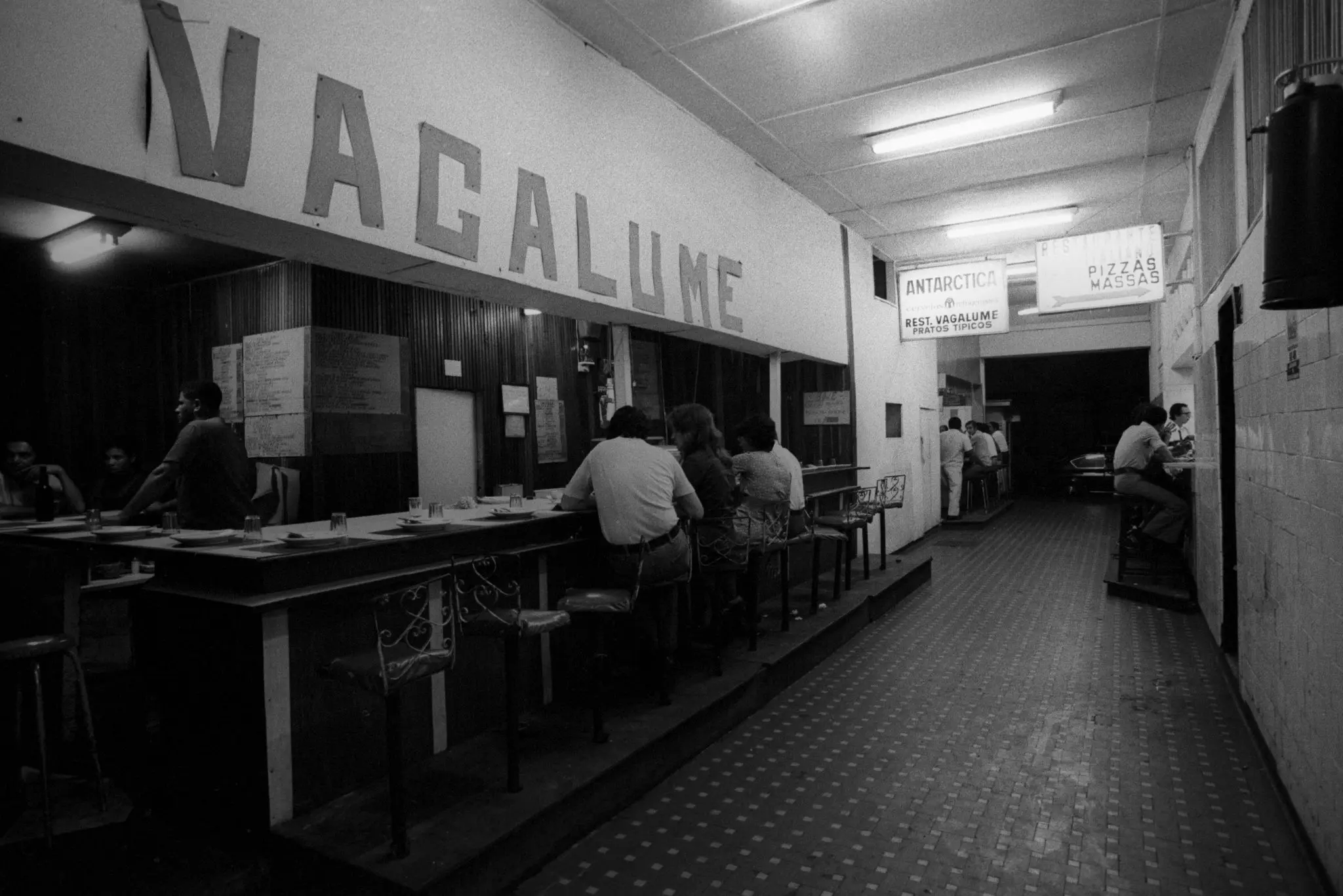 Restaurante localizado no Beco da Fome, Rio de Janeiro, com pessoas conversando e bebendo.