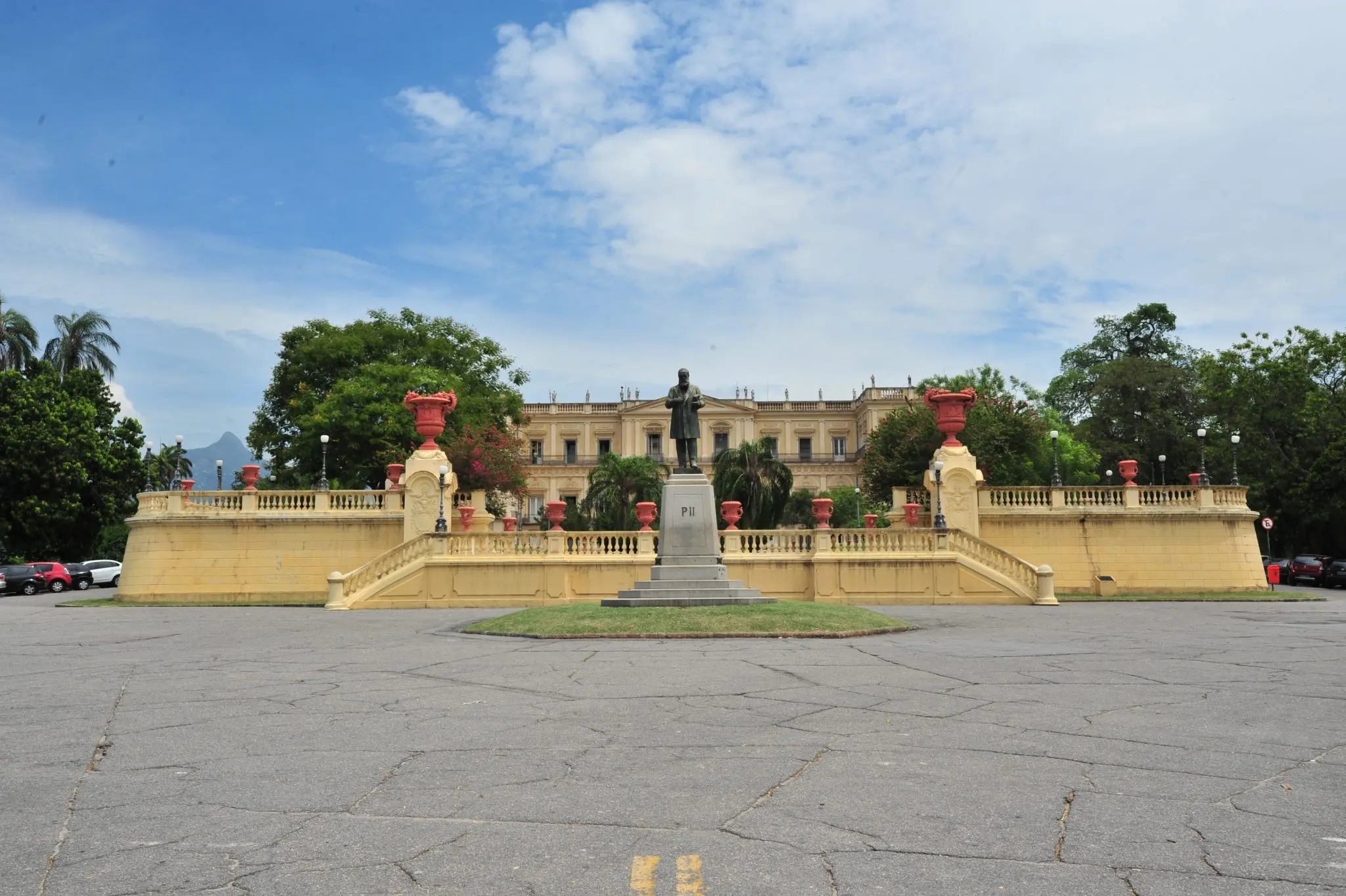 Monumento em frente a palácio com estátua e escadaria.