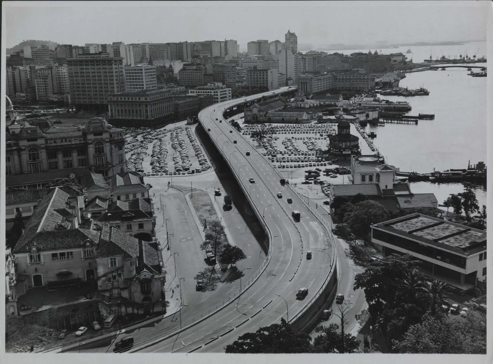 Cidade urbana com viaduto, edifícios históricos e porto.