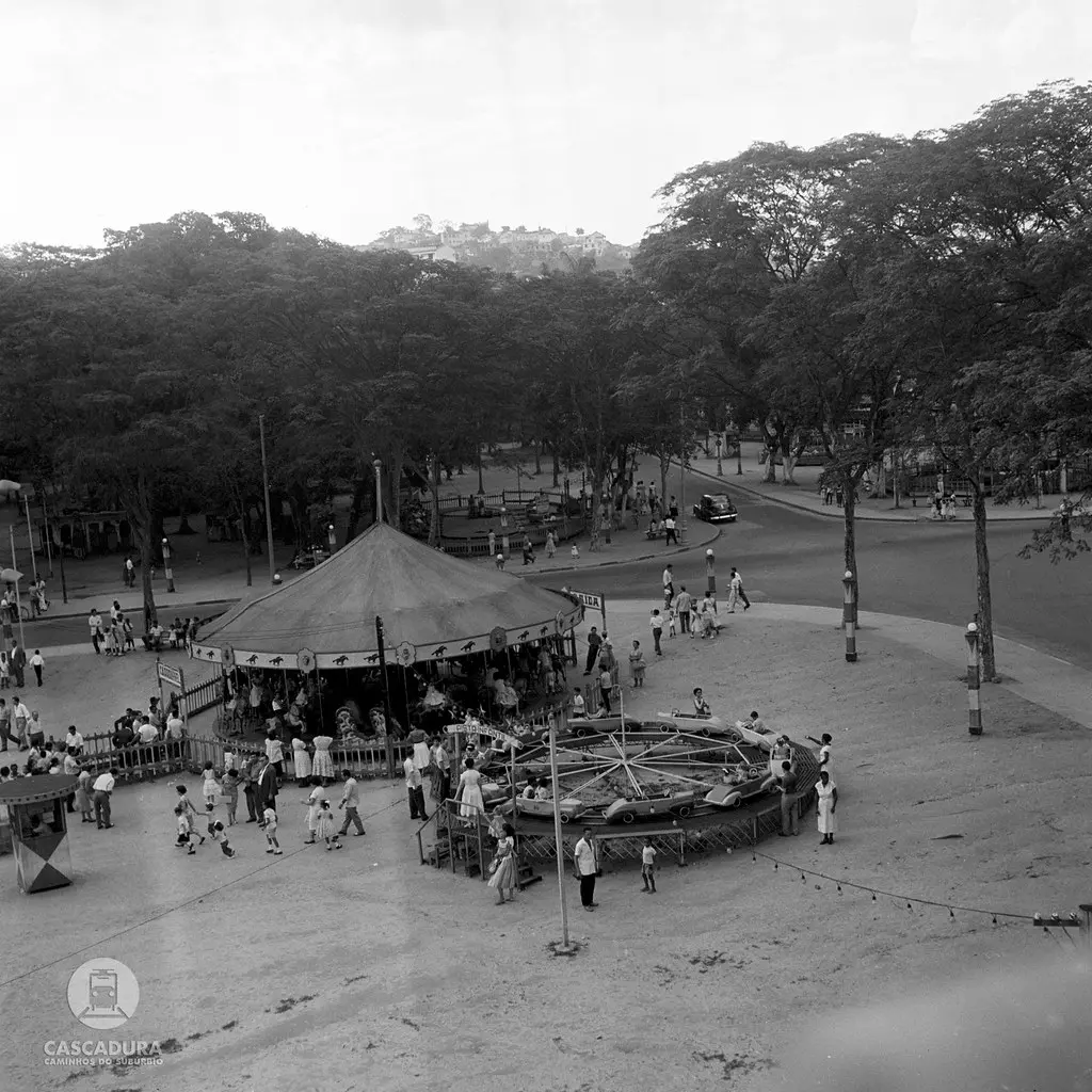 Parque com estrutura circular, árvores e construção histórica.