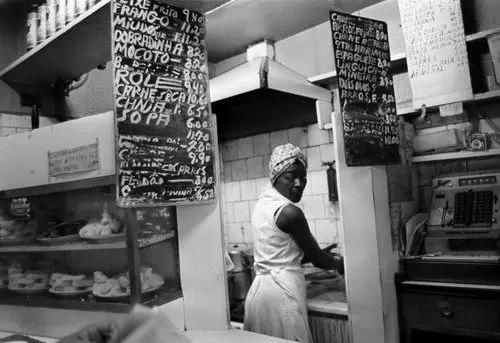 Padaria preto e branco com mulher preparando alimentos.