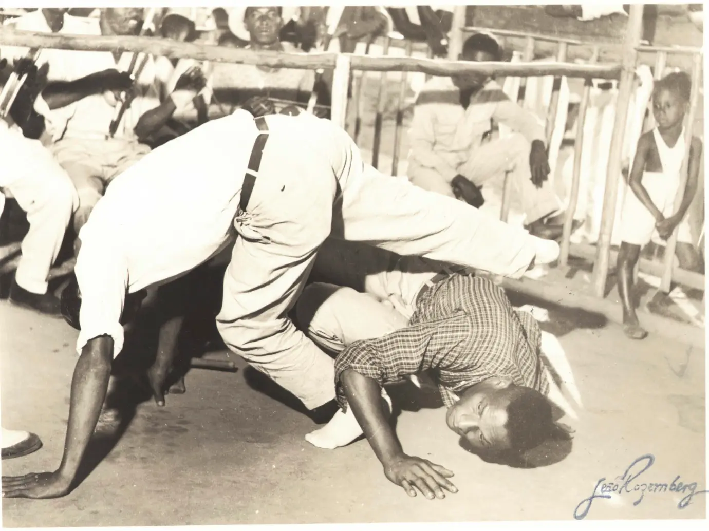 Capoeira em preto e branco, dois homens em ação.
