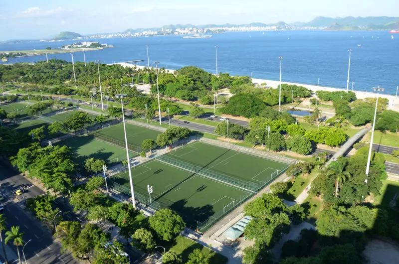 Parque com campos de futebol e vista para água e montanhas.