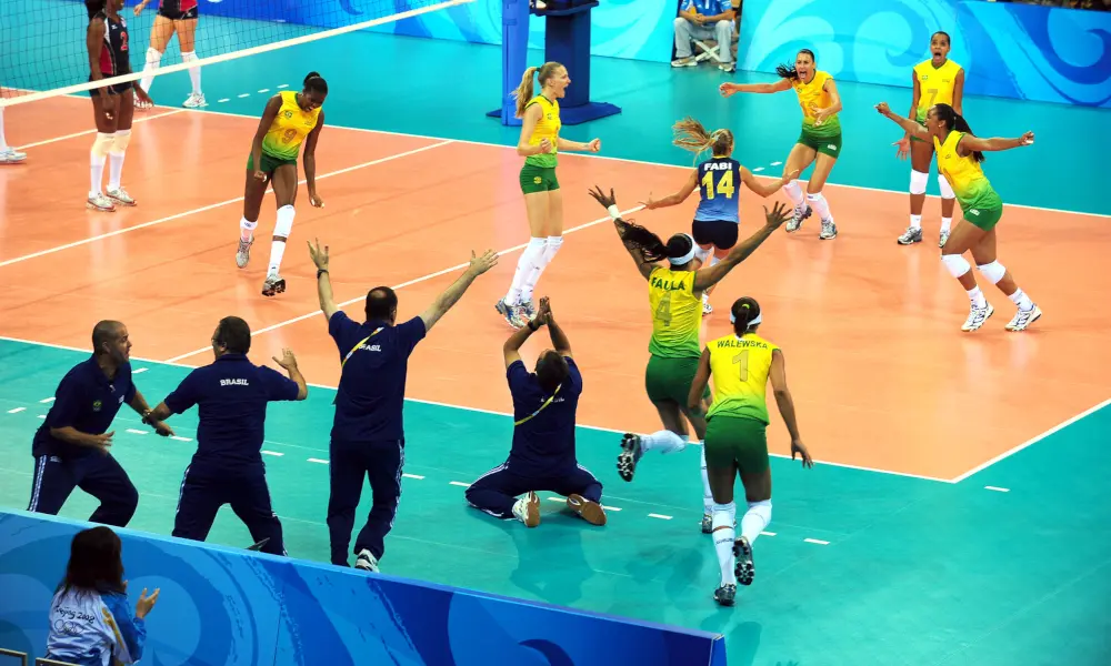 Partida de vôlei com celebração do time brasileiro.
