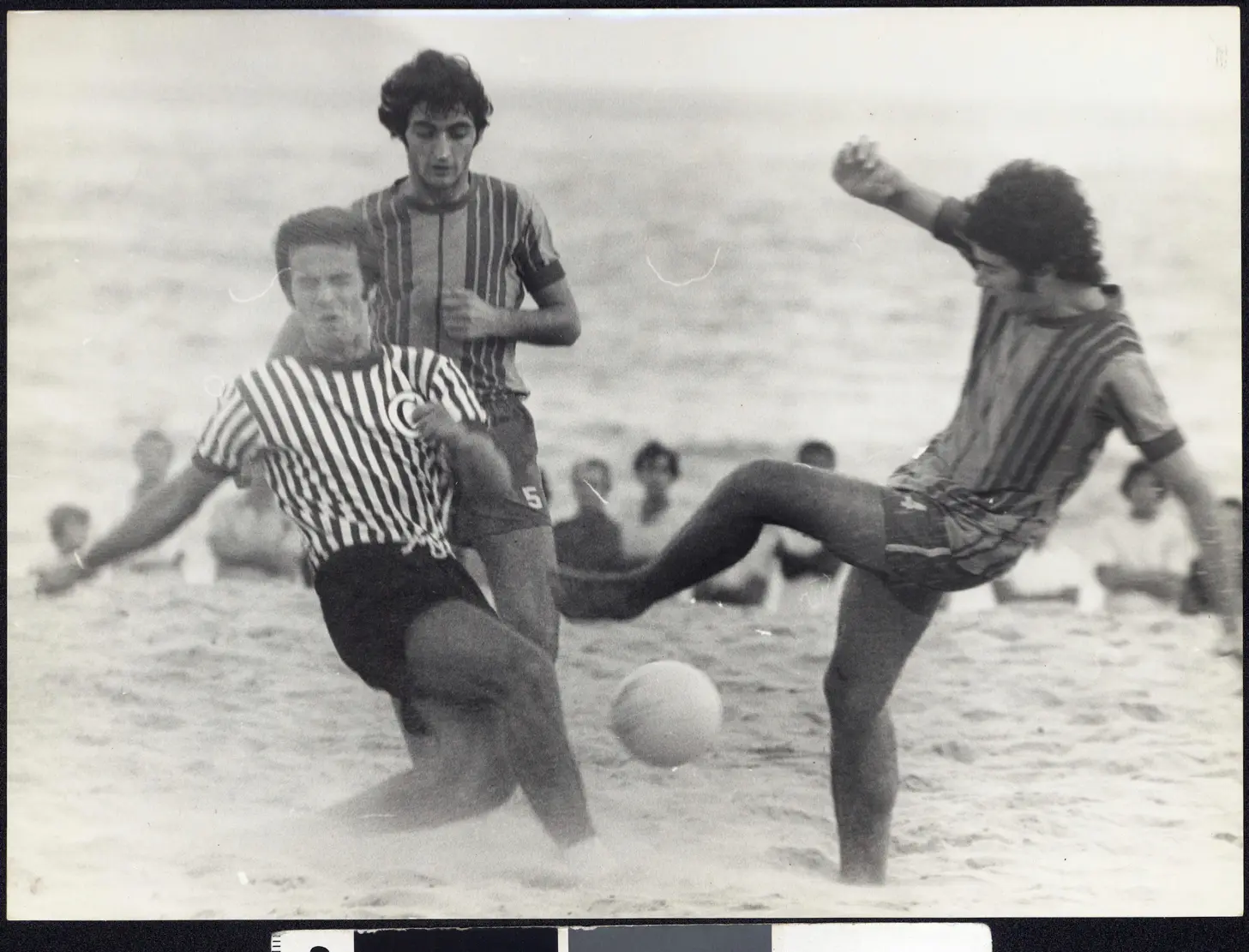 Jogadores em ação durante um jogo de futebol de praia.