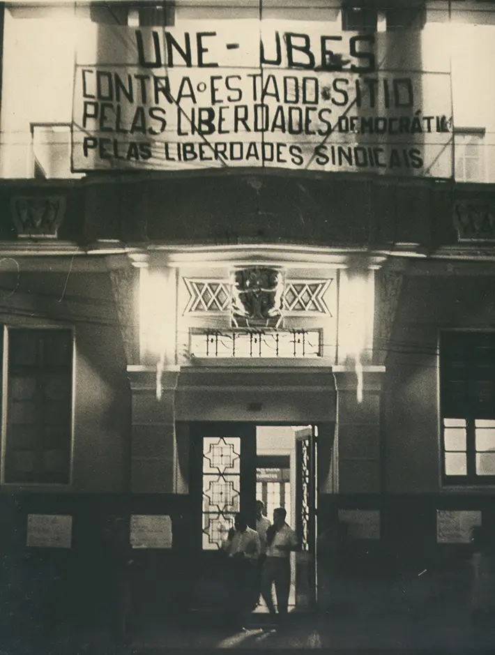 Entrada de edifício com sinal sobre liberdades democráticas e sindicais.
