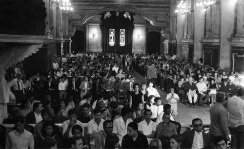 Missa de sétimo dia em igreja, com fiéis sentados e em pé.