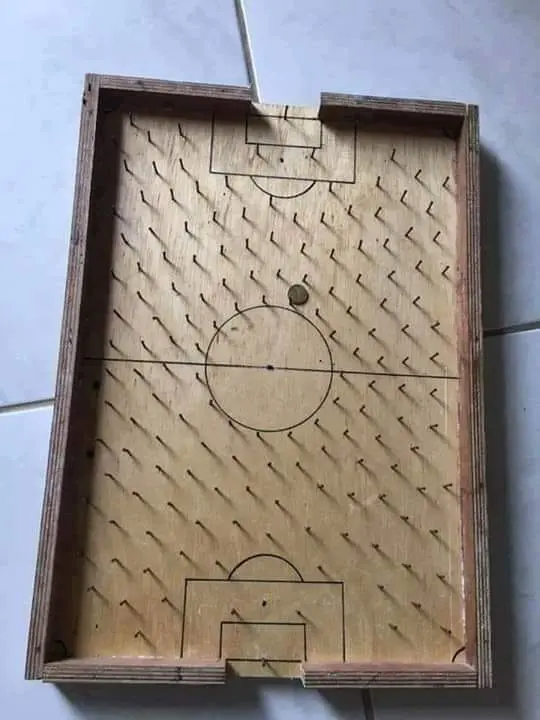 Tabuleiro de jogo de madeira com linhas e círculos geométricos.