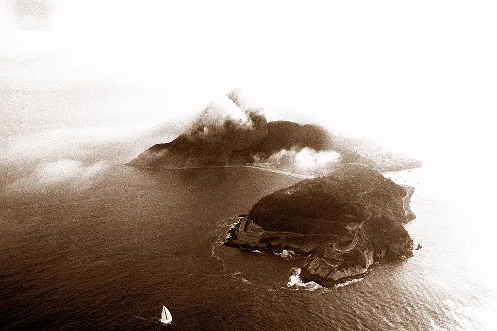 Ilha com fortificação, água e embarcação.