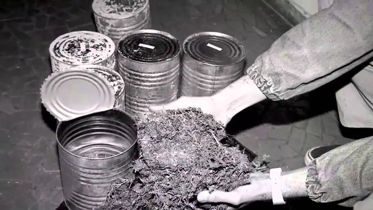 Objetos metálicos e latas em preto e branco.