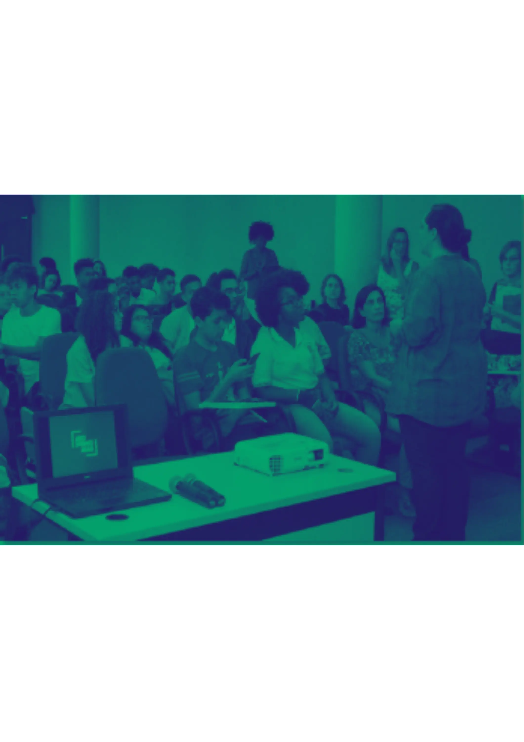 Sala de conferências com laptop, projetor e apresentação em curso.