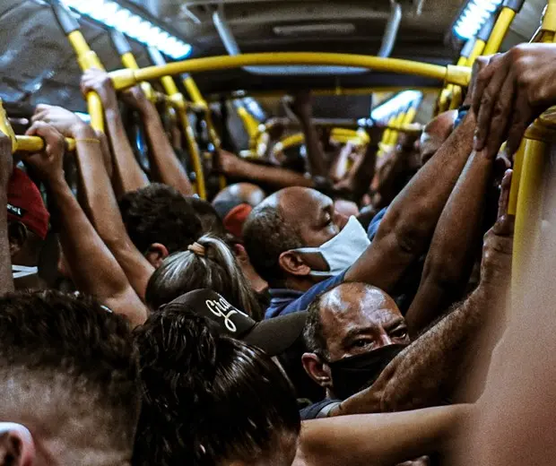 Ônibus lotado durante pandemia, pessoas usando máscaras.