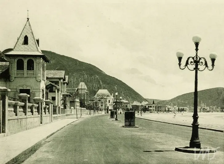 Copacabana antiga com edifício inclinado e montanha ao fundo.