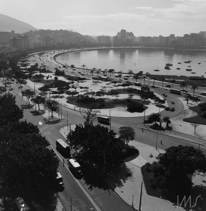 Um aterro costeiro com vegetação, parque e estrada em movimento.