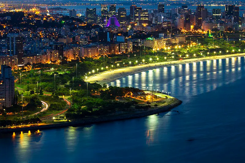 Aterro do Flamengo noturno, iluminação contrastante entre verde e cidade.
