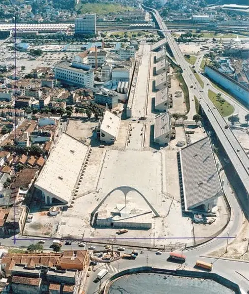 Área urbana com edifícios residenciais, complexo arquitetônico e via expressa.