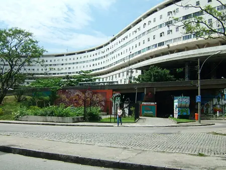 Imagem urbana de prédios e pessoas caminhando.