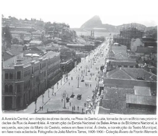 Fotografia preto e branco de avenida em centro urbano com prédios históricos e montanha ao fundo.