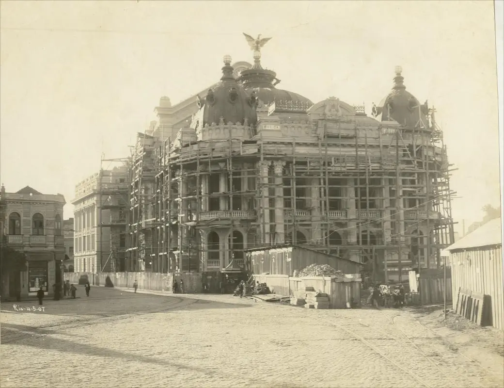 Teatro em construção com telhado decorativo e águia.