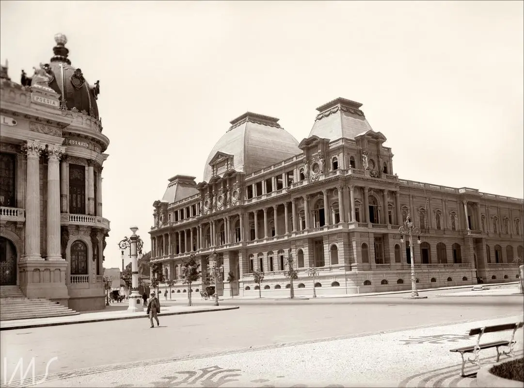 Praça histórica com palácio clássico e edifício central.