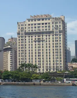 Edifício urbano com árvores e céu azul.