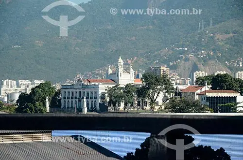 Edifício histórico em vista urbana com palácio branco e montanhas verdes ao fundo.