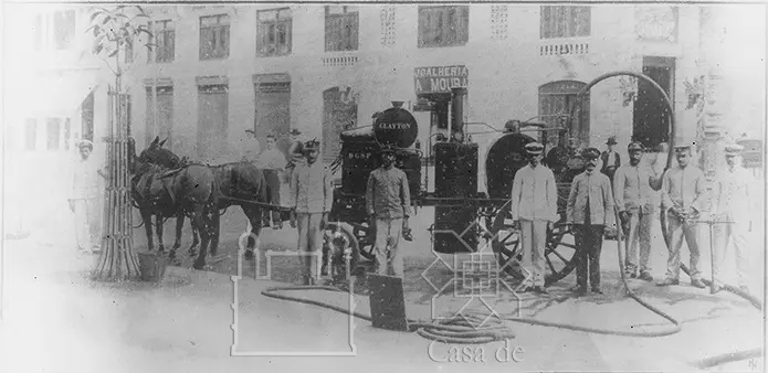Foto em preto e branco do Serviço de Profilaxia da Febre Amarela: equipe uniformizada e máquina a vapor puxada por cavalos, 1905.