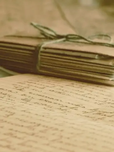 Caderno antigo com folha em destaque, caligrafia irregular.