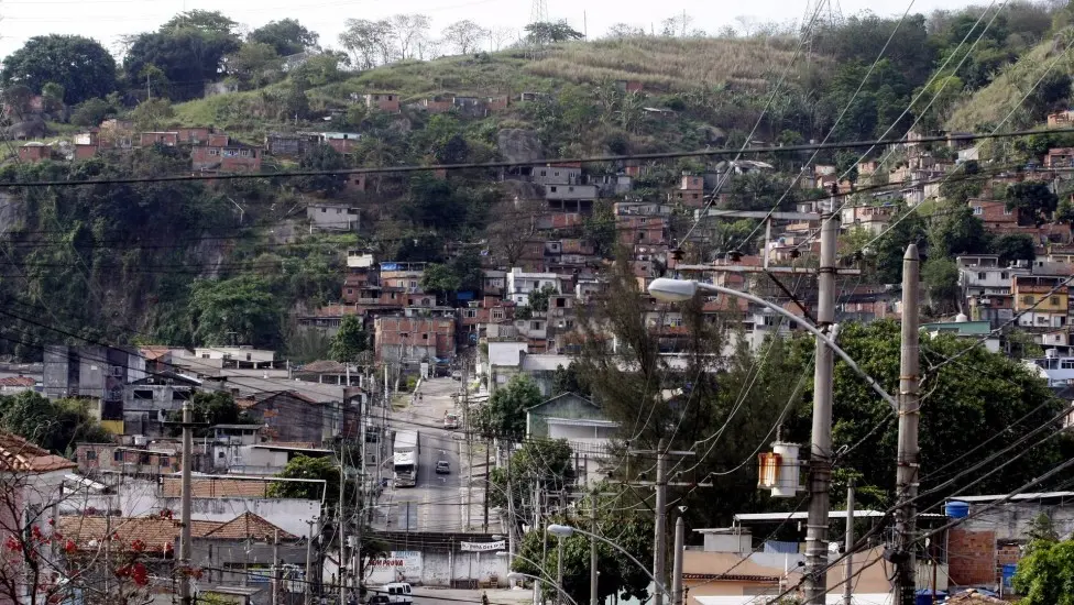 Comunidade urbana em vale com casas coloridas e estrada.