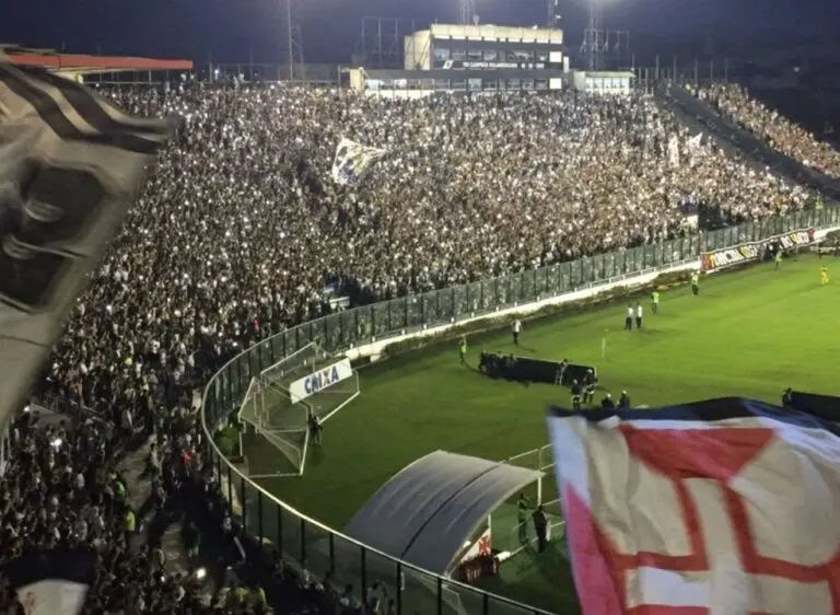 Estádio lotado durante evento esportivo noturno.