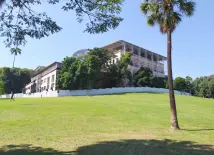 Parque com casa histórica e construção moderna.