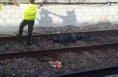 Pessoas em trilhos ferroviários, vista linear.