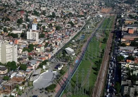 Área urbana com bairro residencial, via férrea e parque verde.