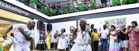 Evento cultural em shopping com dança de samba de roda.