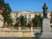 Edifício histórico com escadaria e estátua.