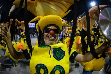 Festa de Carnaval com trajes coloridos e brilhantes.