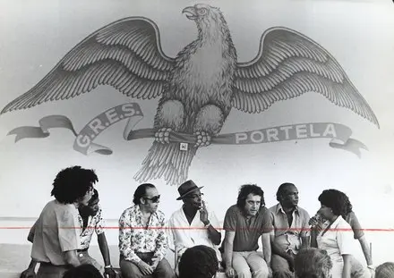 Escola de samba da Portela com águia e pessoas coloridas.
