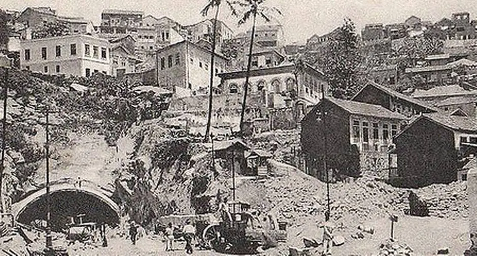 Cena urbana antiga com túnel, casas e igreja.
